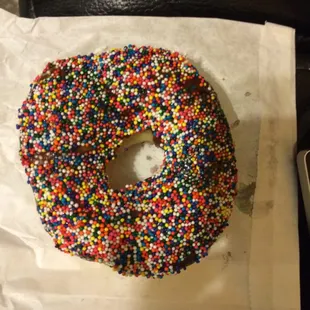 a sprinkled donut on a piece of paper