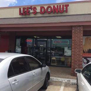 two cars parked in front of a donut shop