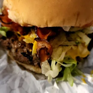 a hamburger with bacon and lettuce