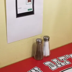 a sign on a table with salt and pepper shakers