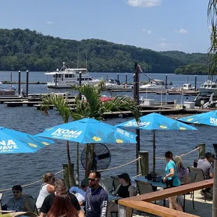 people sitting at tables with blue umbrellas