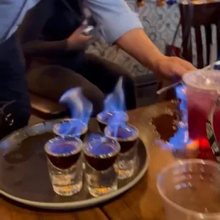 a woman lighting a candle on a table