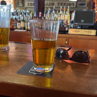 two glasses of beer on a bar