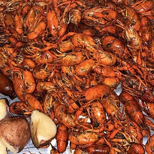 a pile of craws, corn and potatoes