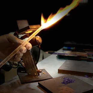 Showing me how to put the glass to a torch