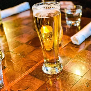 a glass of beer on a wooden table