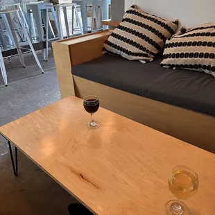a dog laying on the floor next to a table with a glass of wine on it