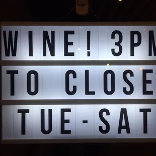 a sign that reads wine 3pm to close tuesday - sat