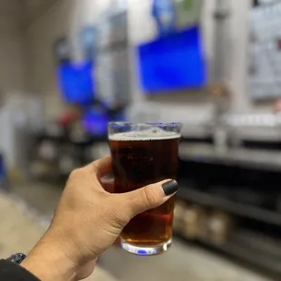 a person holding a glass of beer