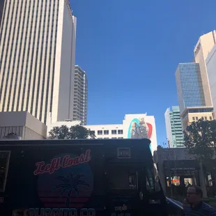 a black food truck in the middle of a city