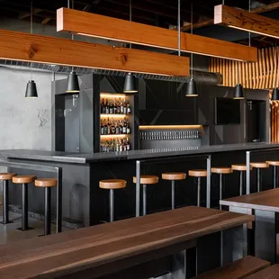 a bar with wooden stools and tables