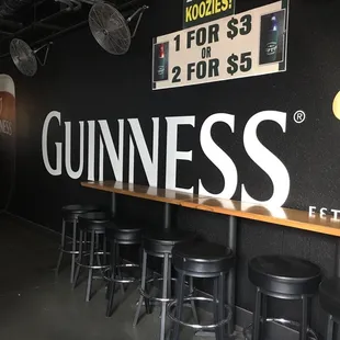 a bar with stools and a guinness sign