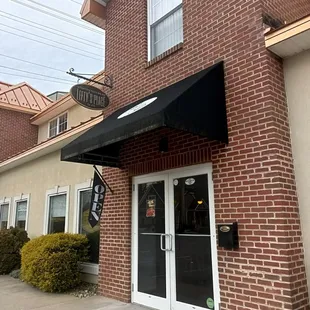 a brick building with a black awning