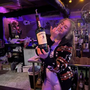 a woman holding a bottle of liquor