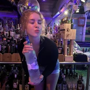 a woman holding a bottle of vodka