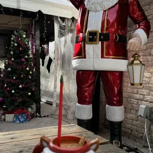 a statue of santa holding a cup of coffee
