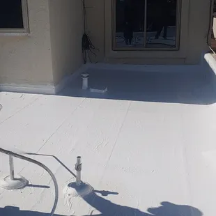 a man using a hose to clean a flat roof