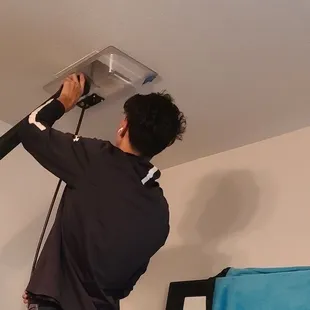 a man installing a ceiling fan