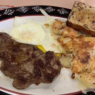 Steak with eggs and potatoes, toasts on the side.