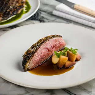 a plate of meat and vegetables on a marble table