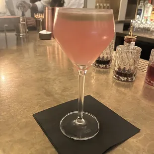 a glass of pink wine on a bar