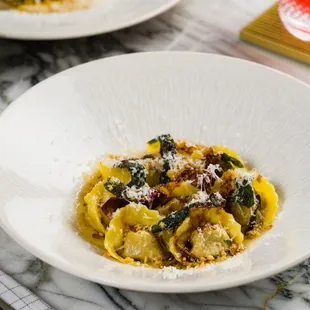 a plate of pasta and a bottle of wine