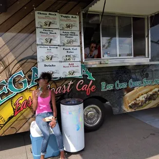 a woman standing in front of a food truck