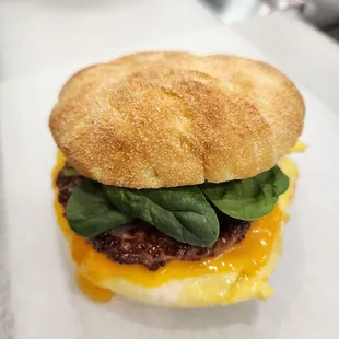 a breakfast sandwich with cheese and spinach