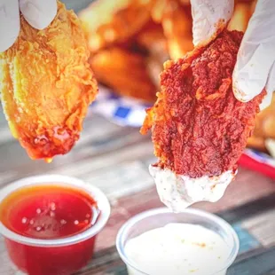 a hand holding a piece of fried chicken