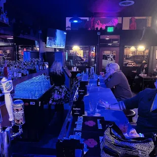 a bar with people sitting at the bar