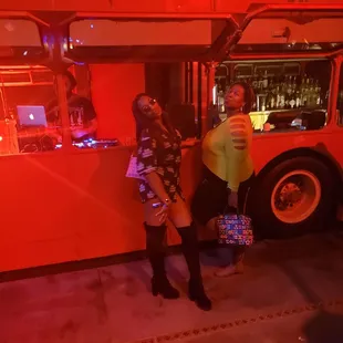 a man and a woman standing in front of a double decker bus