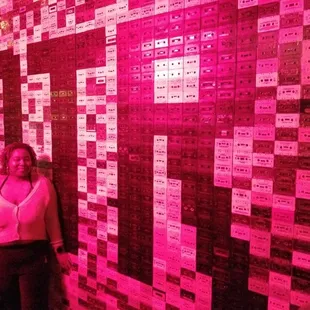 a woman standing in front of a wall of tickets