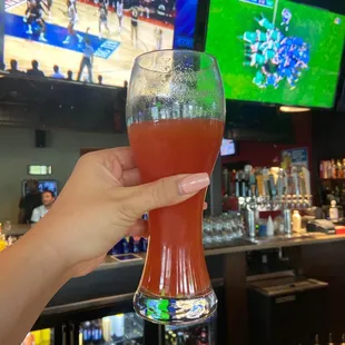 a person holding a glass of beer