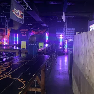 a long wooden bar with neon lights