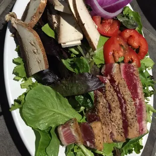 a plate of salad with meat and vegetables