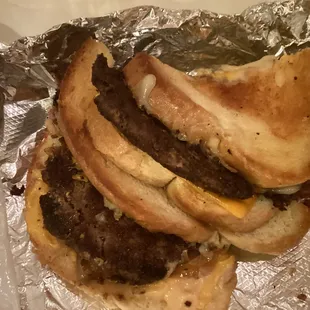 A thin burnt burger in a patty melt