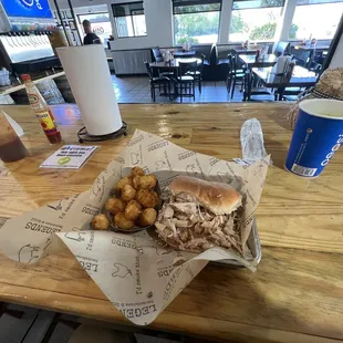 Pulled chicken sandwich with a side of seasoned tater tots
