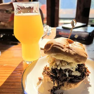 a pulled pork sandwich and a glass of beer