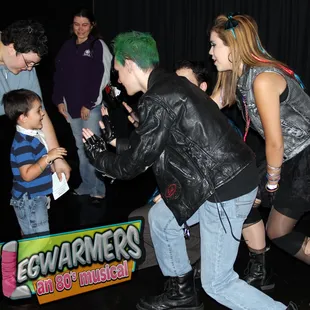 a man with green hair and a woman in a black leather jacket