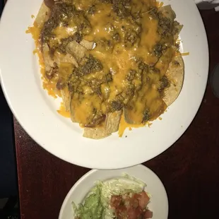 a plate of nachos and salad