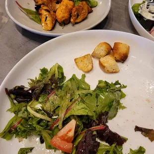 Partially eaten garden salad with chicken meat from a kebab.