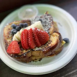 a plate of french toast with strawberries and bananas