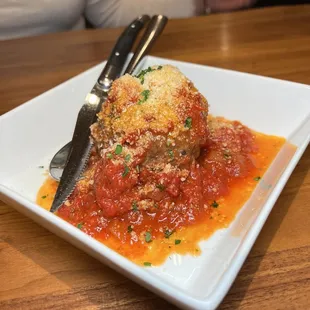 a plate of meatballs with sauce and parmesan cheese
