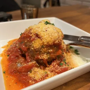 a plate of meatballs with sauce and parmesan cheese
