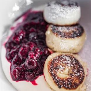 Syrniki (cottage cheese pancakes) w/ seasonal berry coulis and whipped sour cream ($16)