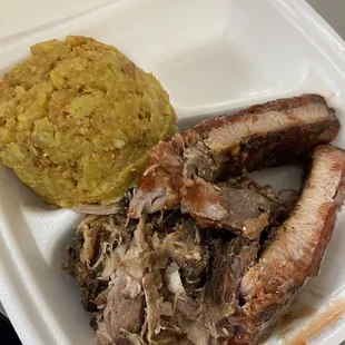 a styrofoam container with meat and rice