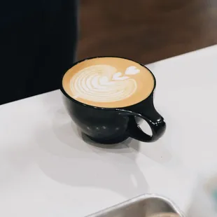 a latte in a black cup