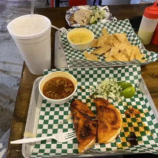 a plate of chicken, tortillas, salsa, and chips