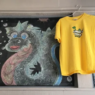 a yellow t - shirt and a chalk drawing of a cat