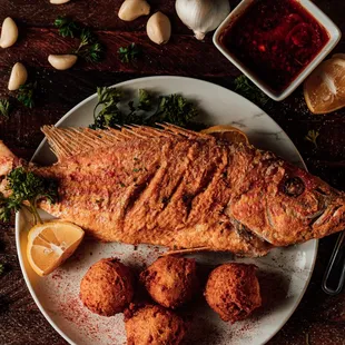 a plate of fried fish with a side of vegetables